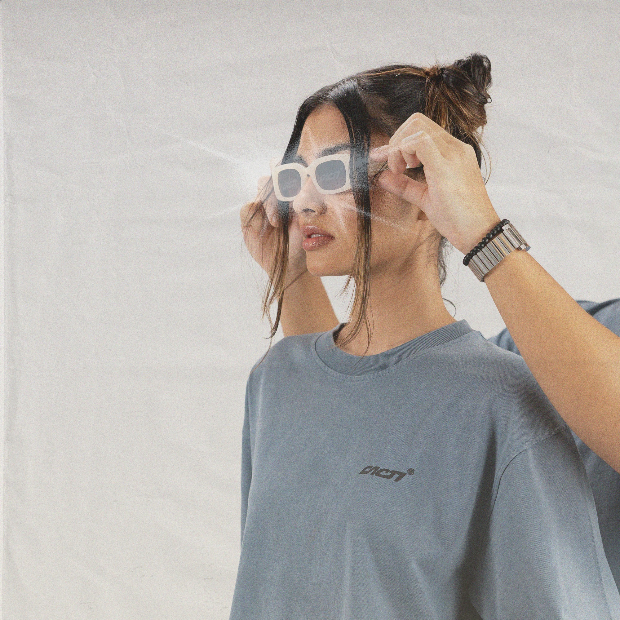 Model wearing blue t-shirt and sunglasses